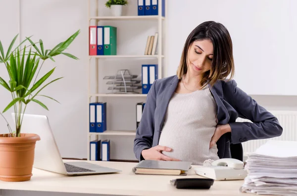 Giovane lavoratrice incinta che lavora in ufficio — Foto Stock