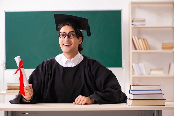 Estudante graduado na frente do quadro verde — Fotografia de Stock