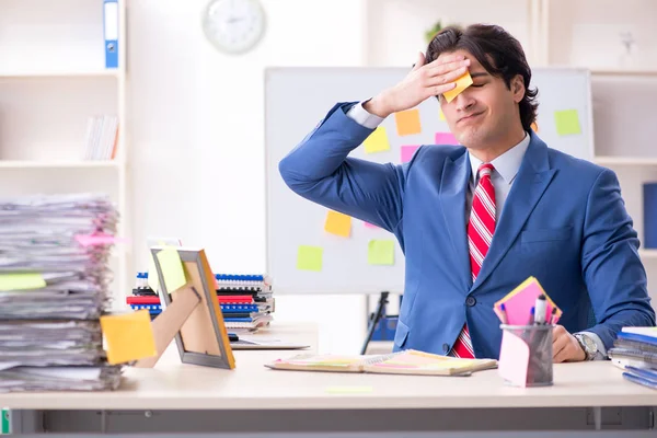 Young male handsome employee in conflicting priorities concept — Stock Photo, Image