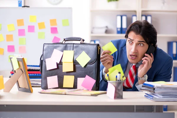 Young male handsome employee in conflicting priorities concept — Stock Photo, Image