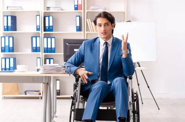 Mannelijke werknemer in rolstoel werken op kantoor — Stockfoto