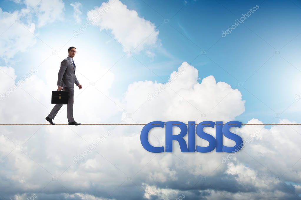 Crisis concept with businessman walking on tight rope