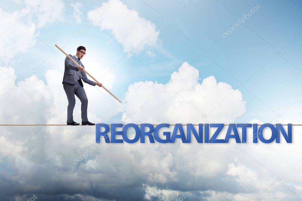Reorganisation concept with businessman walking on tight rope