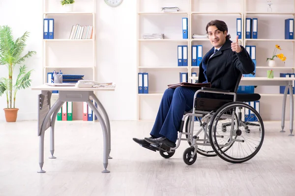 Young male employee in wheelchair working in the office