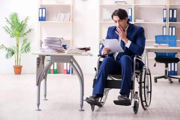 Joven empleado masculino en silla de ruedas que trabaja en la oficina —  Fotos de Stock