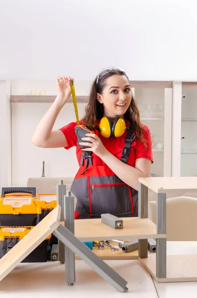 Female contractor repairing furniture at home