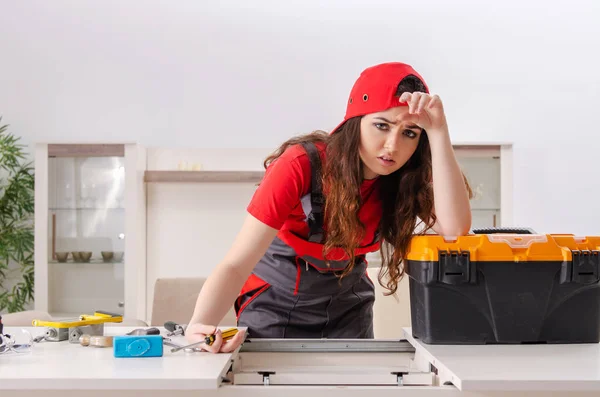 Female contractor repairing furniture at home