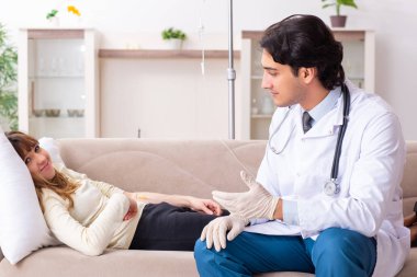 Genç, yakışıklı doktor, kadın hastayı evinde ziyaret ediyor. 