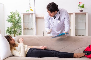 Genç, yakışıklı doktor, kadın hastayı evinde ziyaret ediyor. 