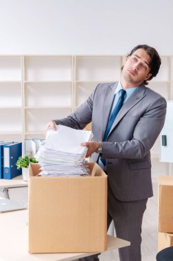 Genç adam çalışan ofiste kutuları ile 
