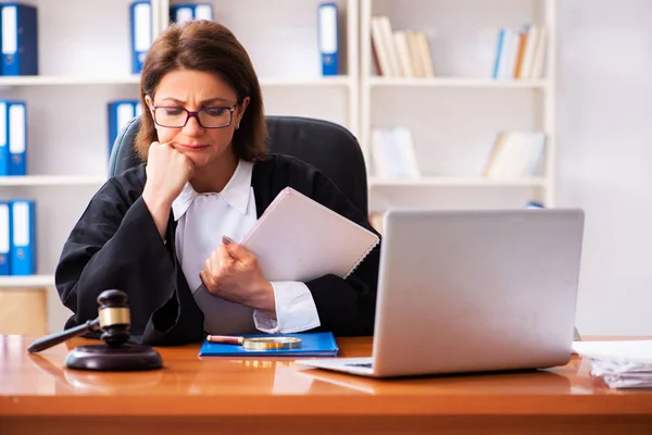 Middle-aged female doctor working in courthouse