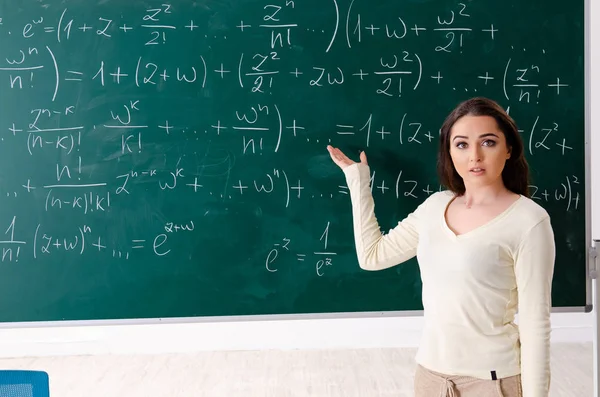 Joven profesora de matemáticas delante de pizarra — Foto de Stock