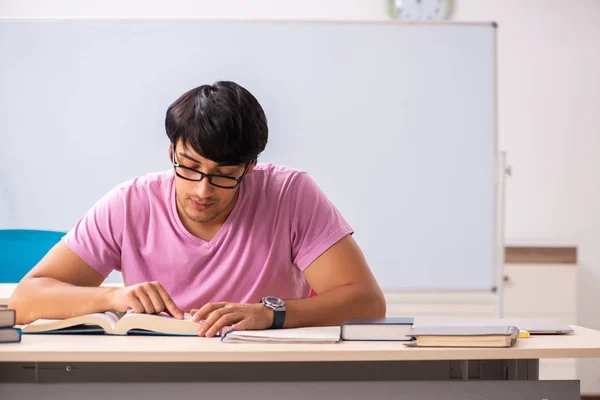 Jonge mannelijke student zitten in de klas — Stockfoto
