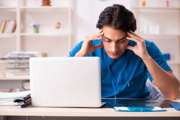 Jonge knappe dokter werkt in de kliniek — Stockfoto