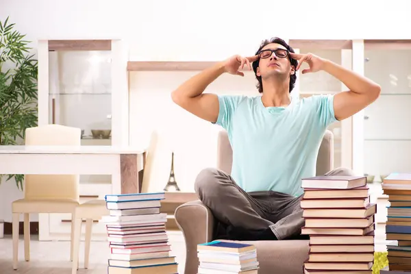 Estudiante masculino con muchos libros en casa — Foto de Stock