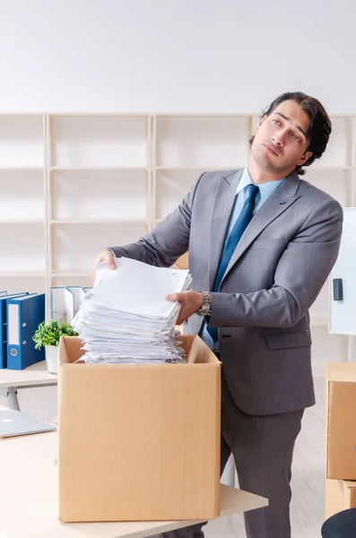 Young man employee with boxes in the office — Stock Photo, Image