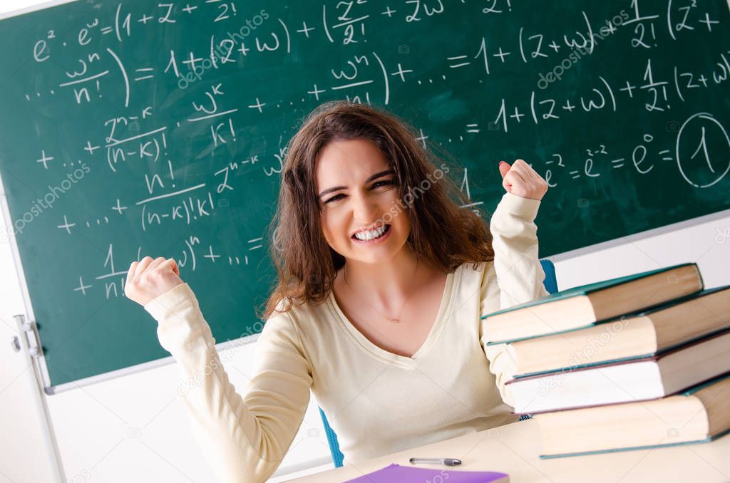 Young female math teacher in front of chalkboard  