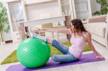 Genç güzel kadın evde egzersizleri yapıyor 