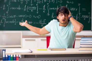 Kara tahta önünde genç erkek öğrenci matematikçi 