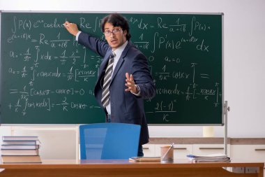 Genç erkek matematik öğretmeni sınıfta 