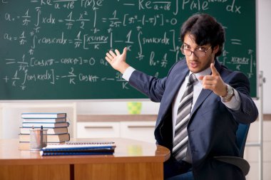 Genç erkek matematik öğretmeni sınıfta 