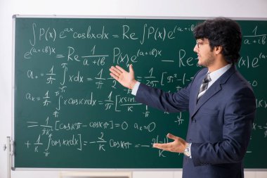 Genç erkek matematik öğretmeni sınıfta 