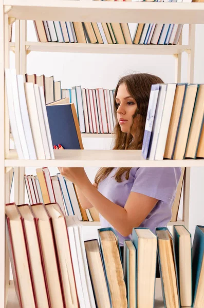 Joven estudiante preparándose para los exámenes en la biblioteca — Foto de Stock