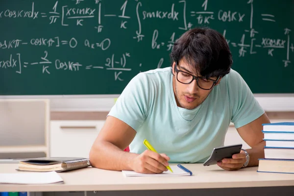Νεαρός φοιτητής αρσενικό μαθηματικός μπροστά από μαυροπίνακα — Φωτογραφία Αρχείου