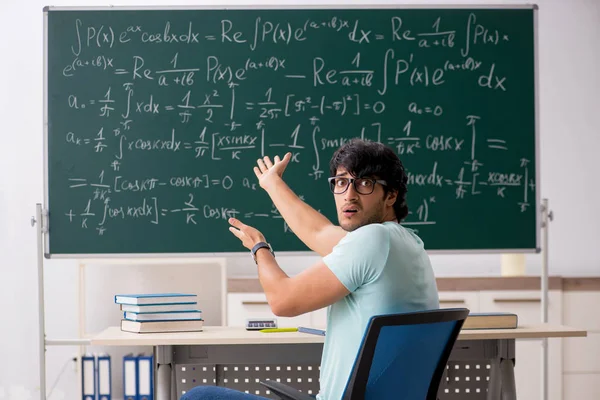 Молодой математик-студент перед доской — стоковое фото