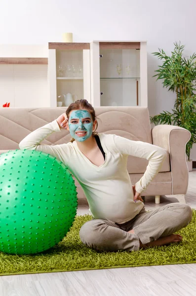 Young pregnant woman doing exercises at home — Stock Photo, Image