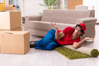 İçeride çalışan kutularla çalışan genç bir erkek müteahhit. 