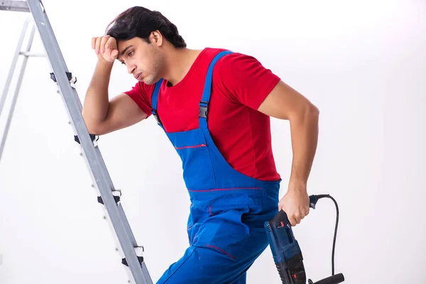 Jovem empreiteiro bonito trabalhando dentro de casa — Fotografia de Stock