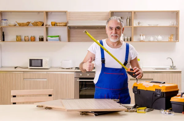 Contratista de edad reparador que trabaja en la cocina — Foto de Stock