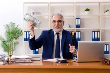 Adliyede çalışan yaşlı bir avukat.  