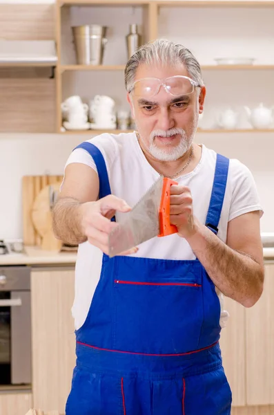 Contratista de edad reparador que trabaja en la cocina — Foto de Stock