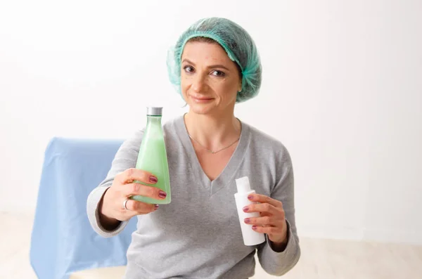 Donna con bottiglie di crema viso — Foto Stock