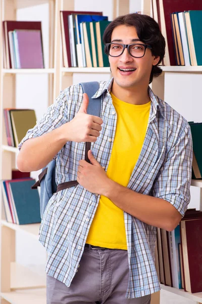Mužský student se připravuje na zkoušky v knihovně — Stock fotografie