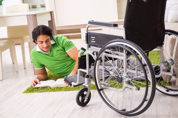 Joven hombre guapo en silla de ruedas en casa —  Fotos de Stock