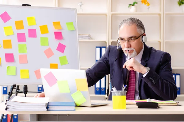 Leeftijd man werknemer in tegenstrijdige prioriteiten concept — Stockfoto