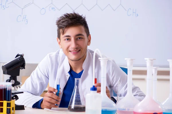 Jeune chimiste assis dans le laboratoire — Photo