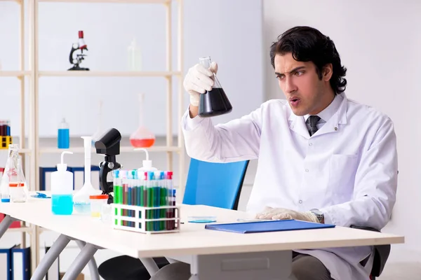 Joven químico guapo trabajando en el laboratorio — Foto de Stock