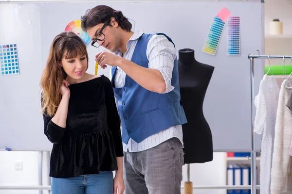 Professional male tailor taking measurements for blouse