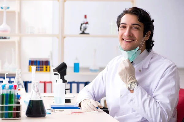 Giovane bel chimico che lavora in laboratorio — Foto Stock