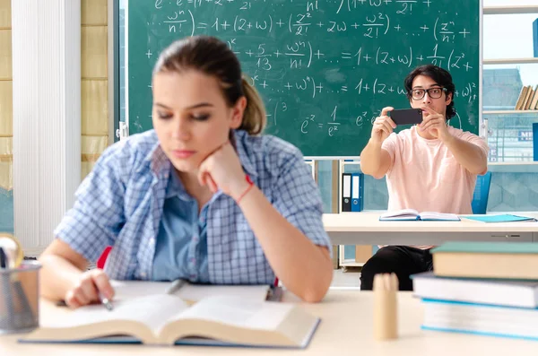Jóvenes estudiantes tomando el examen de matemáticas en el aula — Foto de Stock