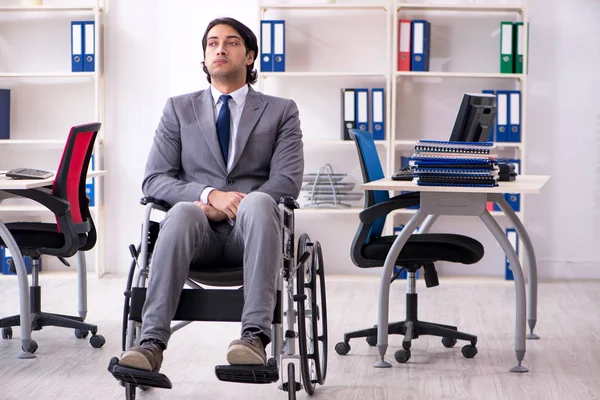 stock image Young handsome employee in wheelchair working in the office  