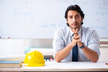 Genç erkek mimar beyaz tahtanın önünde. 