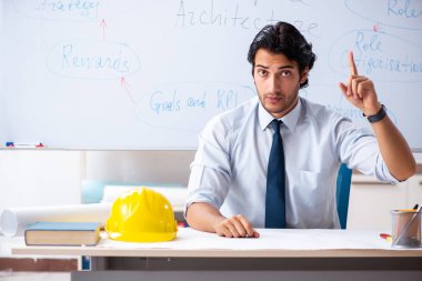 Genç erkek mimar beyaz tahtanın önünde. 