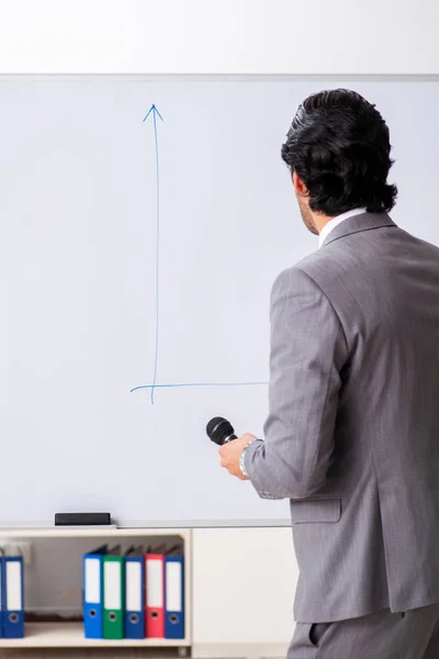 Jeune homme d'affaires beau devant le tableau blanc — Photo