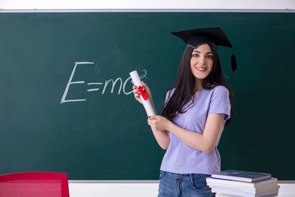 Estudiante graduada frente al tablero verde — Foto de Stock