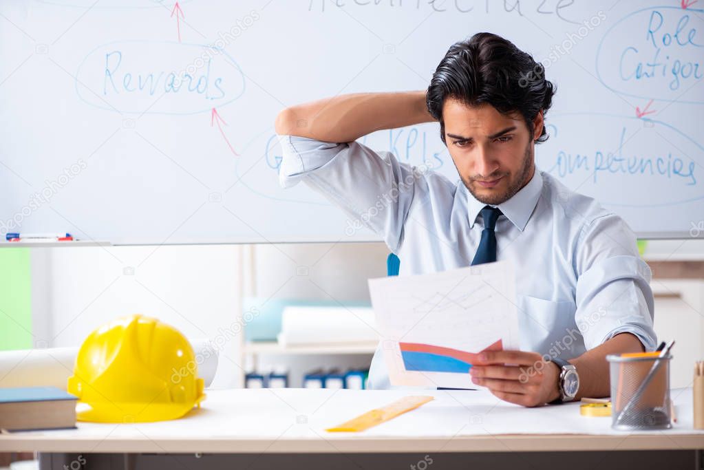 Young male architect in front of the whiteboard 